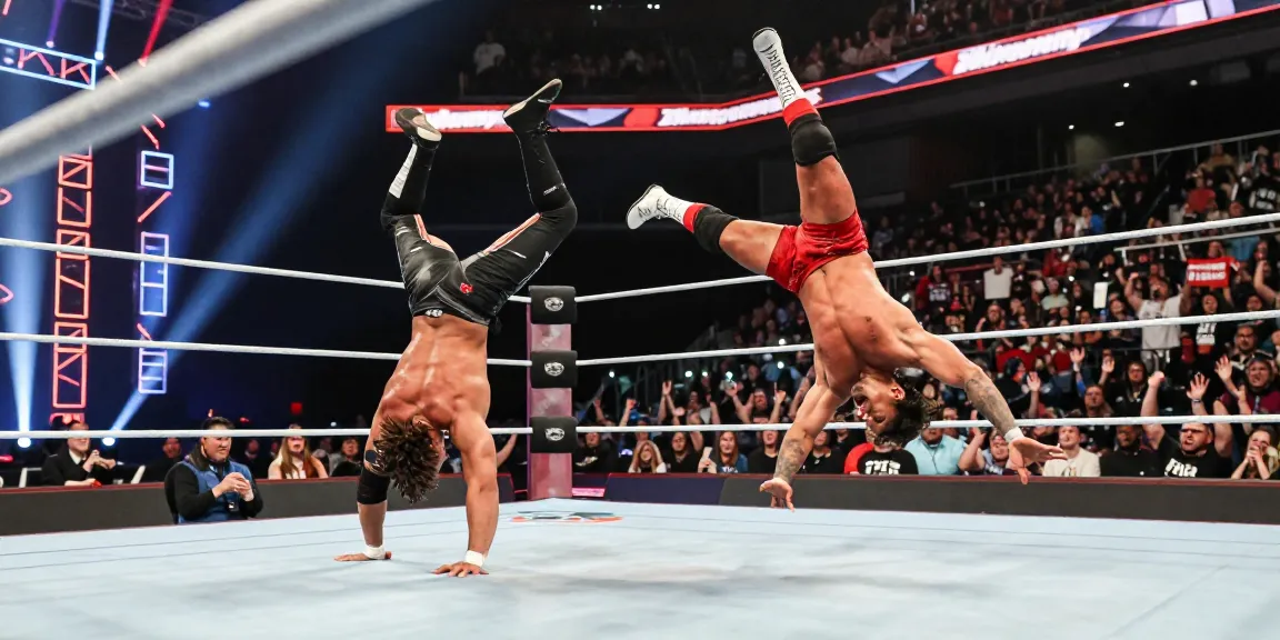 Xavier Woods and Paige thrilling wrestling match in vibrant arena.